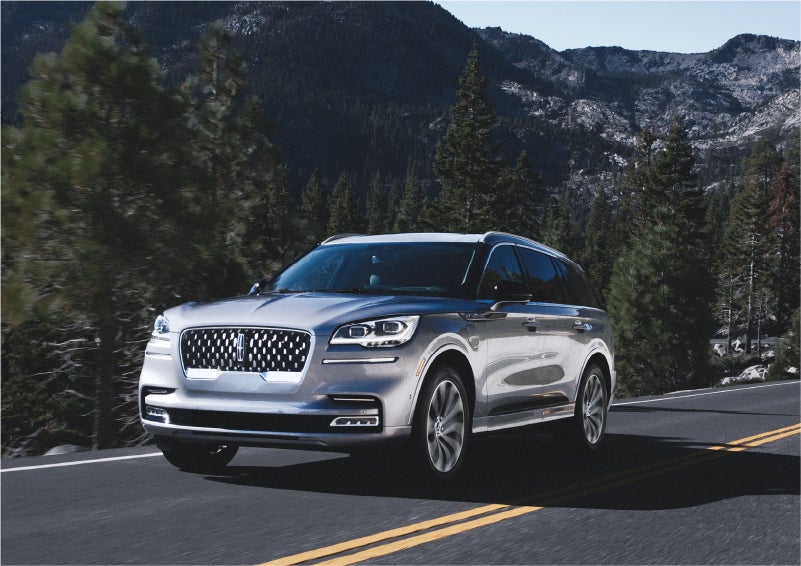 A 2023 Lincoln Aviator® Grand Touring SUV being driven on a winding road to demonstrate the capabilities of all-wheel drive | Wallace Lincoln in Fort Pierce FL