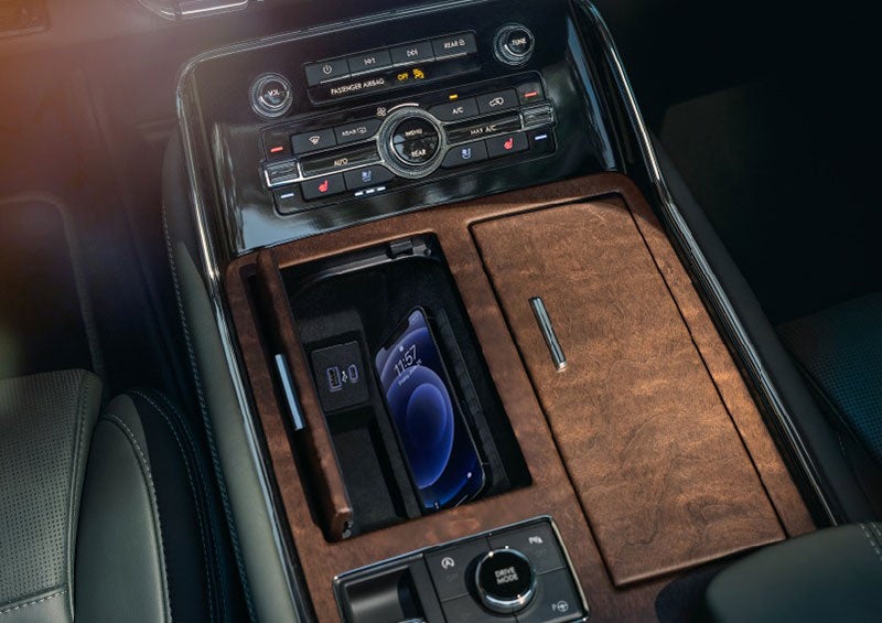 A smartphone is charging on the wireless charging pad* in the front center console cubby. | Wallace Lincoln in Fort Pierce FL