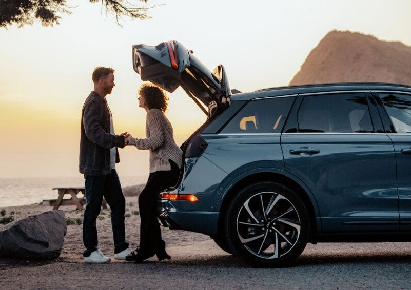 A couple share a moment together outside a 2025 Lincoln Corsair® SUV near the open liftgate. | Wallace Lincoln in Fort Pierce FL
