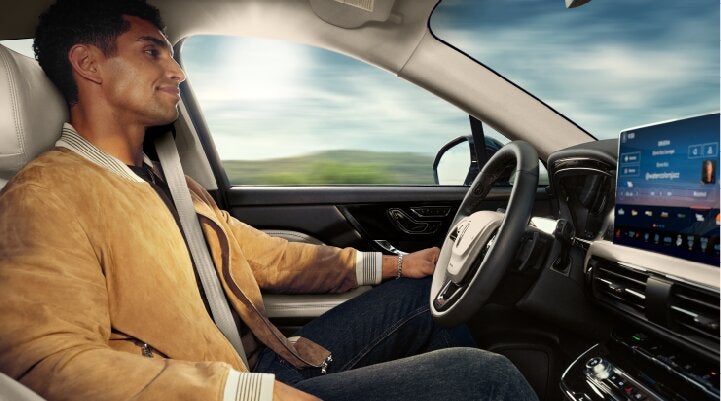 A person is shown using Lincoln BlueCruise hands-free highway driving technology on a divided highway called a Hands-Free Blue Zone. | Wallace Lincoln in Fort Pierce FL