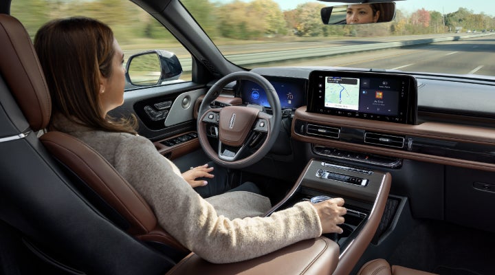 A 2026 Lincoln Aviator® SUV is being driven hands-free on a highway near a forest | Wallace Lincoln in Fort Pierce FL
