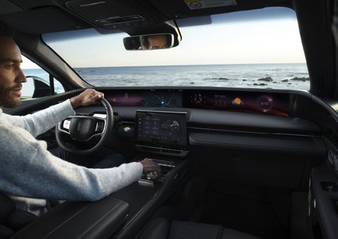 A driver of a parked 2026 Lincoln Nautilus® SUV takes a relaxing moment at a seaside overlook while inside his Nautilus. | Wallace Lincoln in Fort Pierce FL