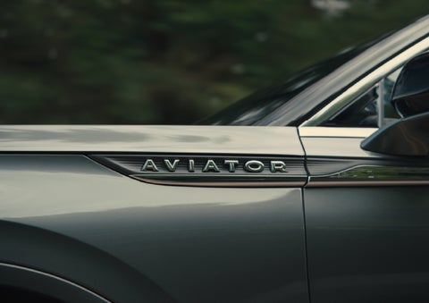 The driver’s side door and fender badging of a gray 2027 Lincoln Aviator® SUV are showcased. | Wallace Lincoln in Fort Pierce FL