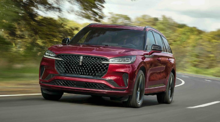 A 2027 Lincoln Aviator® SUV is being driven on a country road | Wallace Lincoln in Fort Pierce FL